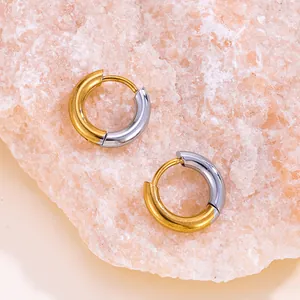 Détail macro de boucles d'oreilles créoles bicolores en acier titane plaqué or 18 carats