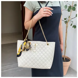 Elegant beige quilted shoulder bag featuring gold chain strap and silk scarf accessory