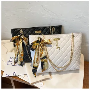 Detailed view of quilted chain shoulder bags featuring elegant silk scarf bow accents