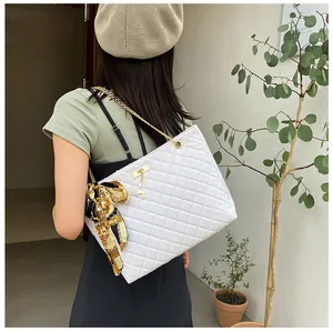 Quilted white shoulder bag with gold chain strap and decorative floral silk scarf
