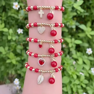 Set di cinque braccialetti di perline rosse e oro con ciondoli a ciliegia e zirconi