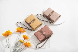 Detailed view of women's short bifold wallets with floral prints and wristlet straps.
