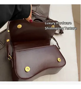 Close-up detail view of a coffee brown leather armpit bag showing gold magnetic snaps