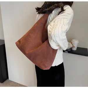 Large brown suede tote bag shown on model's shoulder, perfect for commuter style