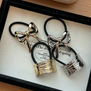 Detailed view of alloy bow and textured gold/silver hair ties in a box