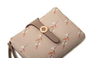 Detailed macro view of women's bifold wallet featuring leaf print and gold flower buckle