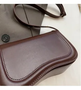Detail of a dark brown Korean style minimalist underarm shoulder bag with smooth finish