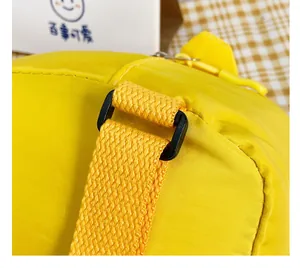 Vue détaillée de la bandoulière tissée jaune et de la boucle noire sur un sac pour enfant