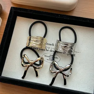 Eleganti elastici per capelli con fiocco in lega oro e argento con dettagli testurizzati.
