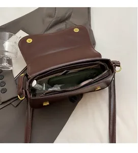 Interior view showing large capacity of a brown small square shoulder bag.