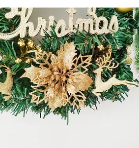 Détail rapproché d'une couronne de Noël avec fleurs à paillettes dorées et rennes