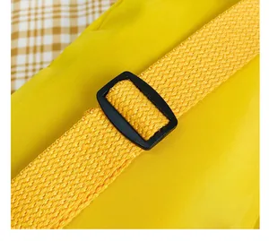 Détail de la bandoulière réglable et de la boucle noire d'un sac jaune pour enfant