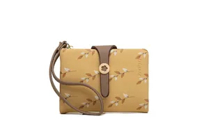 Close-up of yellow women's short wallet with leaf print and flower clasp