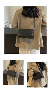 Elegant black underarm bag featuring a unique curved base shown from multiple back angles.