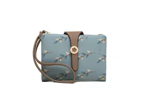 Close-up of a blue leaf-patterned women's wallet with wrist strap and brown buckle detail