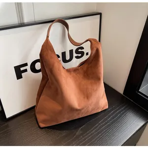 Detailed shot of brown suede hobo bag showing soft texture and elegant curved handle