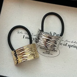 Primo piano di elastici per capelli oro e argento con eleganti dettagli in lega martellata.