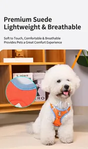 Detail view of breathable orange suede dog harness with reflective trim on white puppy