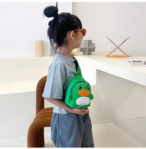 Sac bandoulière canard vert pour enfant porté dans un décor minimaliste moderne