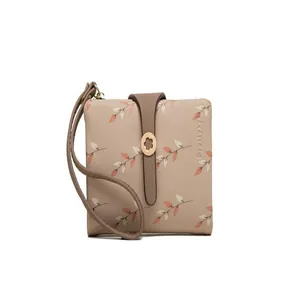 Detailed view of women's short bi-fold wallet with leaf print and wrist strap