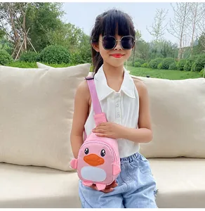Détail d'un sac à bandoulière canard rose porté par une petite fille à l'extérieur