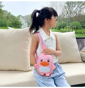 Mignon sac bandoulière canard rose pour enfants porté par un enfant mannequin en extérieur