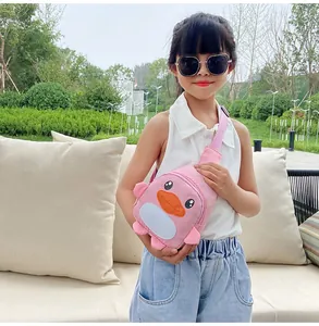 Petite fille portant un sac bandoulière canard rose pour enfants lors d'une sortie.