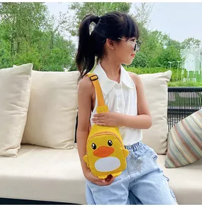 Sac bandoulière canard jaune mignon pour enfant porté par une petite fille en extérieur