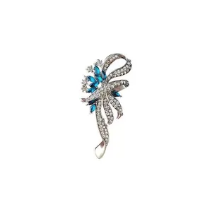 Detail of an elegant ribbon-shaped brooch featuring blue and clear crystal stones