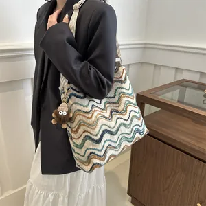 Large capacity woven tote bag with colorful wavy pattern and wide strap worn by a model.