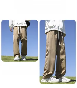 Detailed macro view of men's loose straight cotton casual pants in khaki color outdoors