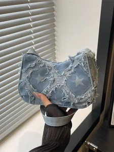Trendy Y2K blue denim underarm bag with frayed star patterns and distressed edges for women