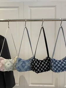 Four casual underarm bags with star and checkered patterns on a hanging rack.