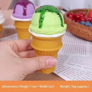Primo piano di un realistico modello di cono gelato verde simulato tenuto in mano per scala