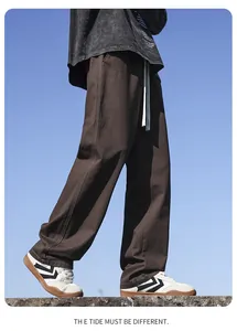 Detailed side view of men's brown loose-fit straight-leg cotton trousers for daily wear.