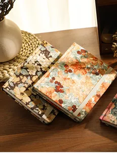Vintage corduroy floral A5 notebook with elastic closure strap on a wooden table