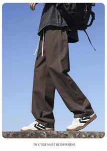 Side view detail of men's loose brown straight-leg cotton casual trousers.