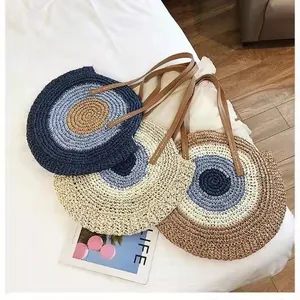 Trio of stylish round straw woven shoulder bags in blue and beige for summer beach