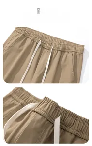 Close-up of men's cotton casual pants featuring elastic waist and white drawstring details.