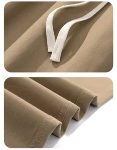 Close-up of premium cotton twill fabric texture and white drawstring detail on khaki pants