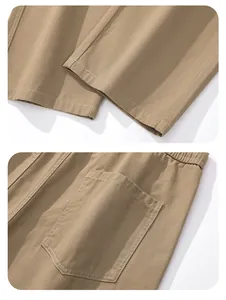 Detail view of khaki cotton trousers showing the hem and back patch pocket.