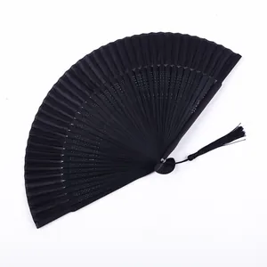 Éventail pliant noir classique avec pompon décoratif, idéal pour la danse et le frais.