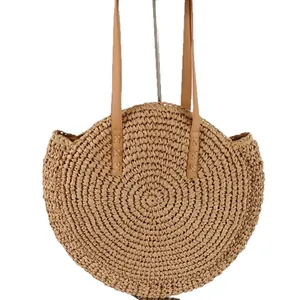 Round woven straw shoulder bag with tan straps, perfect for summer beach vacations.