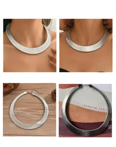 Macro view of textured silver metal choker necklace with ribbed snake bone design.