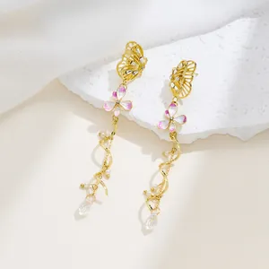 Close-up of luxury gold butterfly drop earrings with pink floral and crystal detail