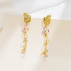 Exquisite detail of golden butterfly earrings with zircon and pink enamel flower