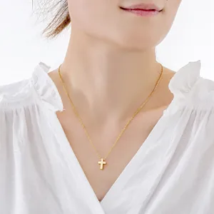 Gedetailleerde weergave van een gouden roestvrijstalen kruisketting op een model.