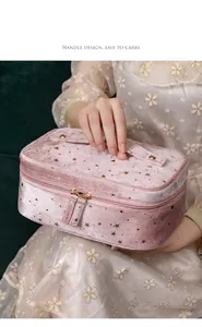 Detail view of pink velvet makeup bag with gold stars and convenient top handle.