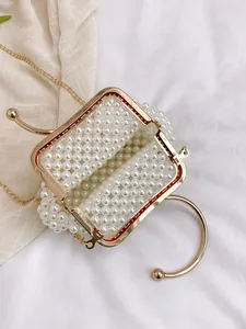 Detailed top view of handmade woven pearl bridal handbag with elegant gold frame.