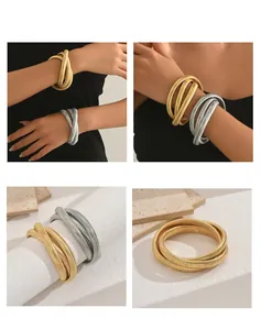 Detail of gold and silver snake bone bracelets showing a textured metallic finish design